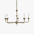 Candle chandelier finish detail showing the textured painted brass surface