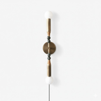 Clérachic wall light on white, white stone spheres capping the top and bottom of a bead-strung brass rod.