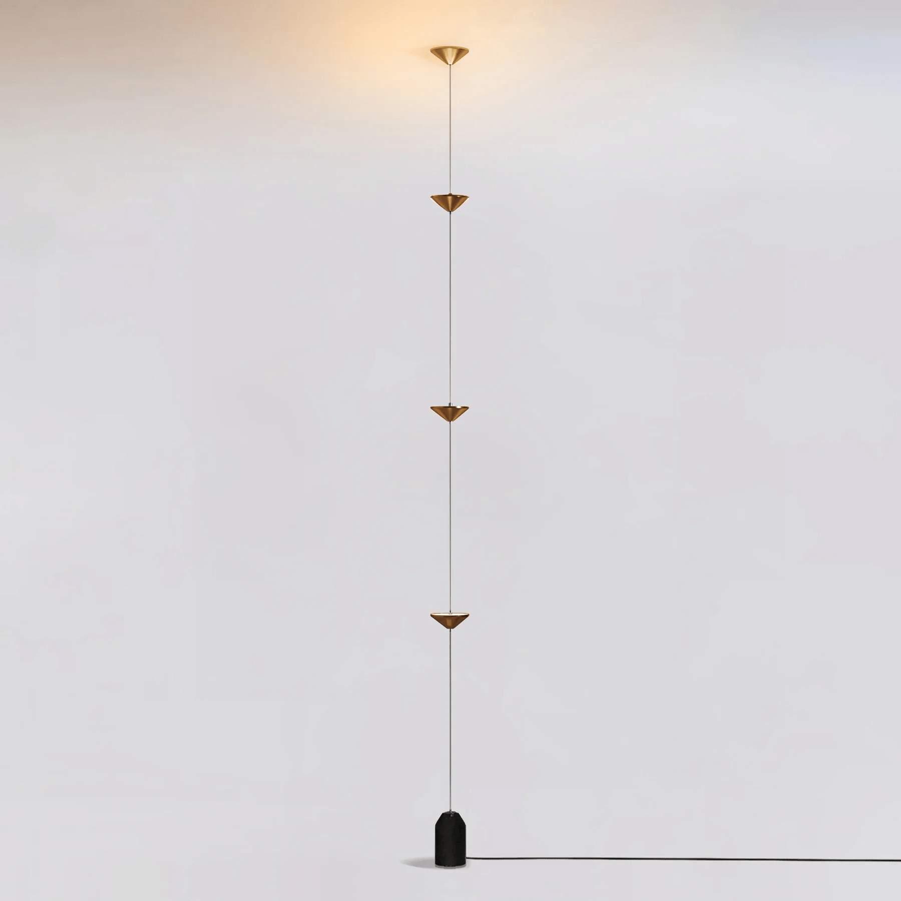 Floor lamp casting warm light against a dark interior wall