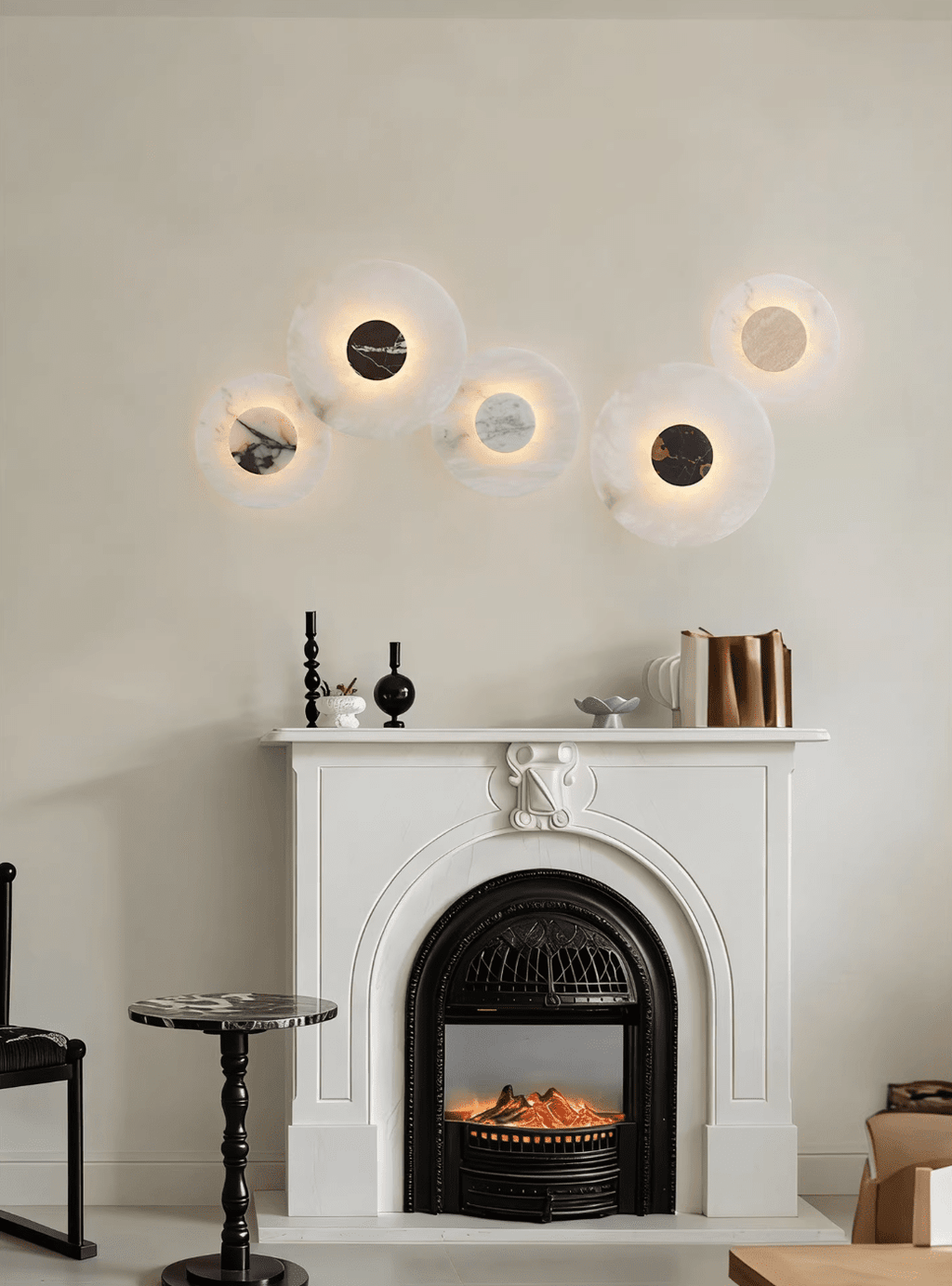 Five Clérachic alabaster disc wall lights glow above a white fireplace mantel set with candlesticks and stacked books.