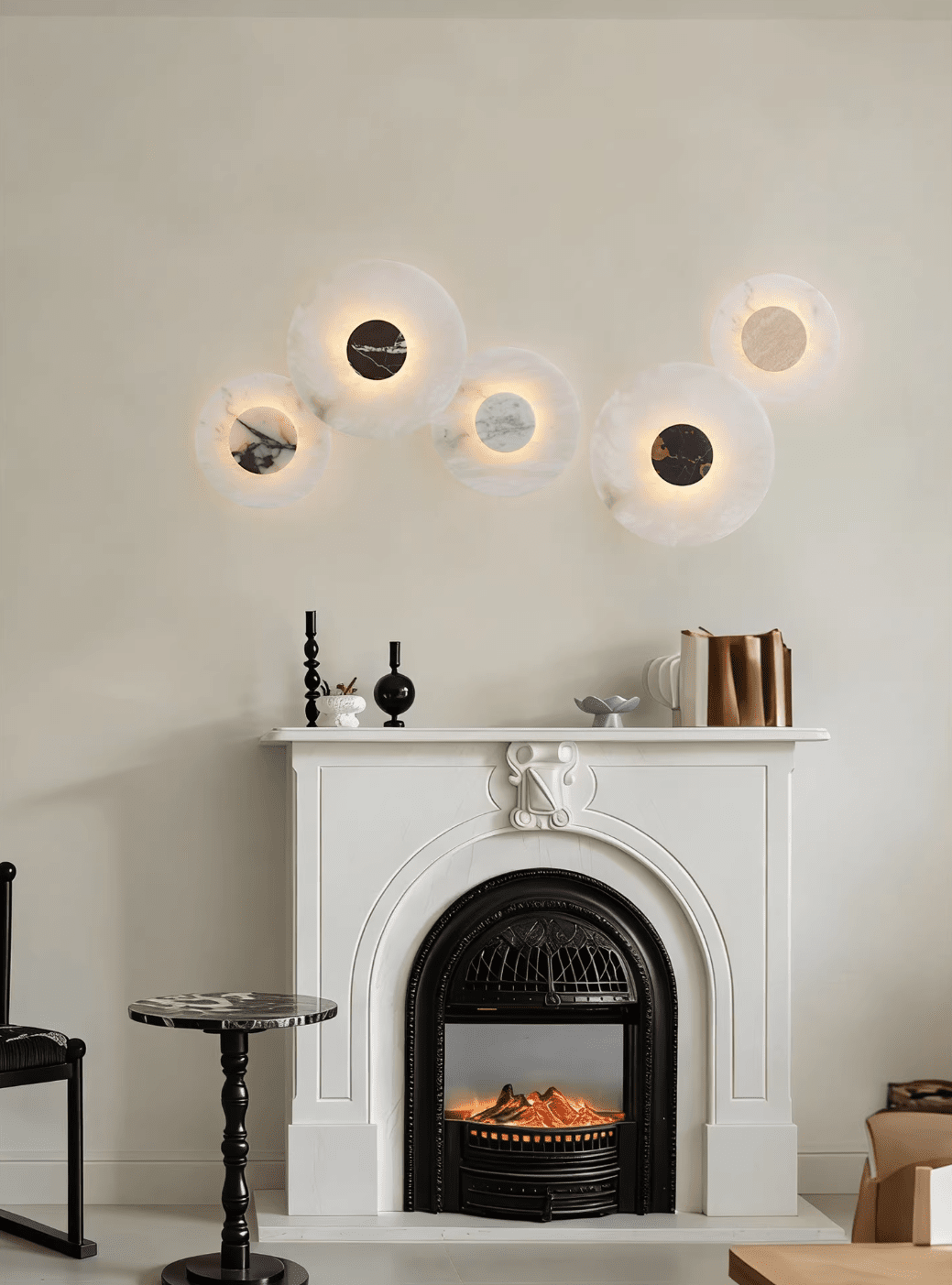 Five Clérachic alabaster disc wall lights glow above a white fireplace mantel set with candlesticks and stacked books.