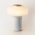 Shot from a slightly lower angle on white, a Clérachic table lamp shows its white marble base and glowing dome shade.
