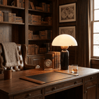 In a dark wood-panelled study, a Clérachic dome table lamp with a black marble base lights a desk beside a clock and whisky glass.