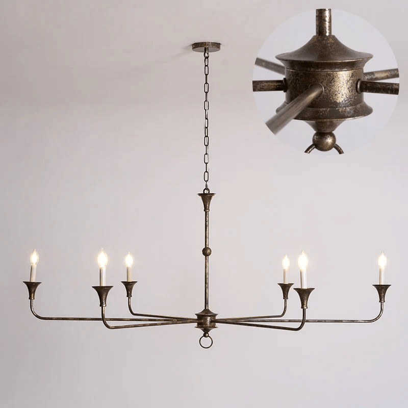 Brass candle chandelier hung above a styled living space