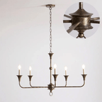 Brass candle chandelier suspended over a dining setting