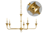 Candle chandelier with tall flame-shaped bulbs glowing in a warm interior