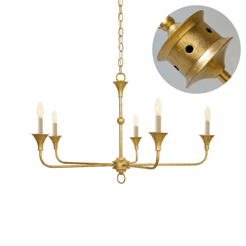 Candle chandelier with tall flame-shaped bulbs glowing in a warm interior