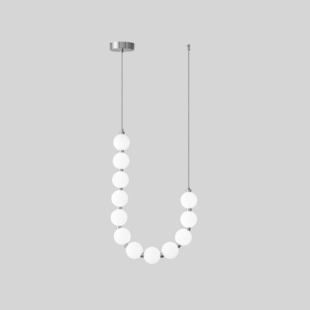 Acrylic pearl chandelier glowing softly above a dining table