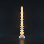 Photographed against a black backdrop, this Clérachic floor lamp's column of glass globes glows softly from top to base.