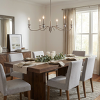 Lit above a long wood table set with a eucalyptus runner, this Clérachic chandelier in brushed nickel hangs before tall curtained windows.