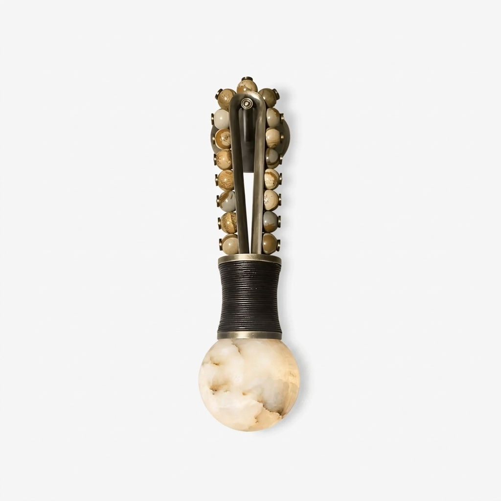 Against a white backdrop, this Clérachic wall light shows its beaded frame rising above a globe of alabaster.