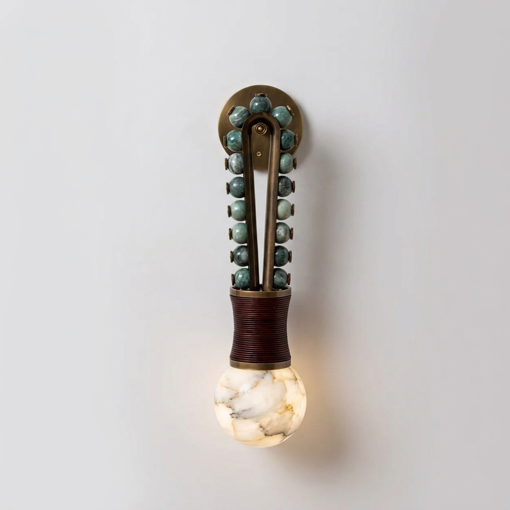 Lit and mounted on a plain wall, this Clérachic wall light glows through its alabaster globe beneath teal-green beads.
