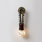 Lit and mounted on a plain wall, this Clérachic wall light glows through its alabaster globe beneath teal-green beads.