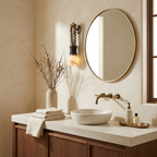 Beside a round brass-framed mirror, this Clérachic wall light lights a plaster-walled powder room.