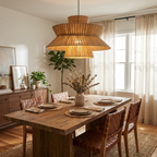 In a dining room with sheer curtains and a potted plant, this Clérachic pendant lights a table set with leather-backed chairs.