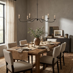 Black and without lampshades, this Clérachic chandelier hangs above a wood dining table set against dark grey walls.
