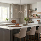 A satin nickel Clérachic chandelier, shown without lampshades, hangs above a kitchen island with grey upholstered stools.