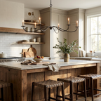 With bare candle bulbs and a black finish, this Clérachic chandelier hangs above a kitchen island lined with leather stools.