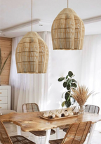 This Clérachic pendant is shown in a pair, hanging above a live-edge dining table with a eucalyptus centrepiece.