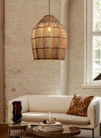 In a brick-walled room, this Clérachic pendant glows warmly above a cream sofa with a patterned cushion.