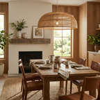 In an open room with a fireplace and tall windows, this Clérachic pendant hangs above a wood dining table.