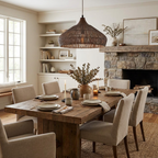 This Clérachic pendant hangs above a wood dining table near a stone fireplace and built-in shelving.