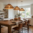 Three of this Clérachic pendant hang over a kitchen island with white cabinetry and tall windows behind.