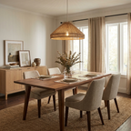 This Clérachic pendant hangs above a wood dining table with cream upholstered chairs, a sideboard of framed art behind.