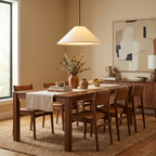 Above a walnut dining table set for a family meal, this beige Clérachic cone pendant glows warmly.