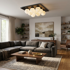 Over a charcoal sectional sofa beneath an abstract print, this Clérachic ceiling light clusters its globes in matte black.