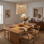 Above a walnut dining table set for a meal, this Clérachic pendant glows beneath abstract wall art and wishbone chairs.