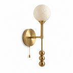 This Clérachic wall sconce in brushed brass shows its pull-chain switch hanging beside the stacked metal balls.
