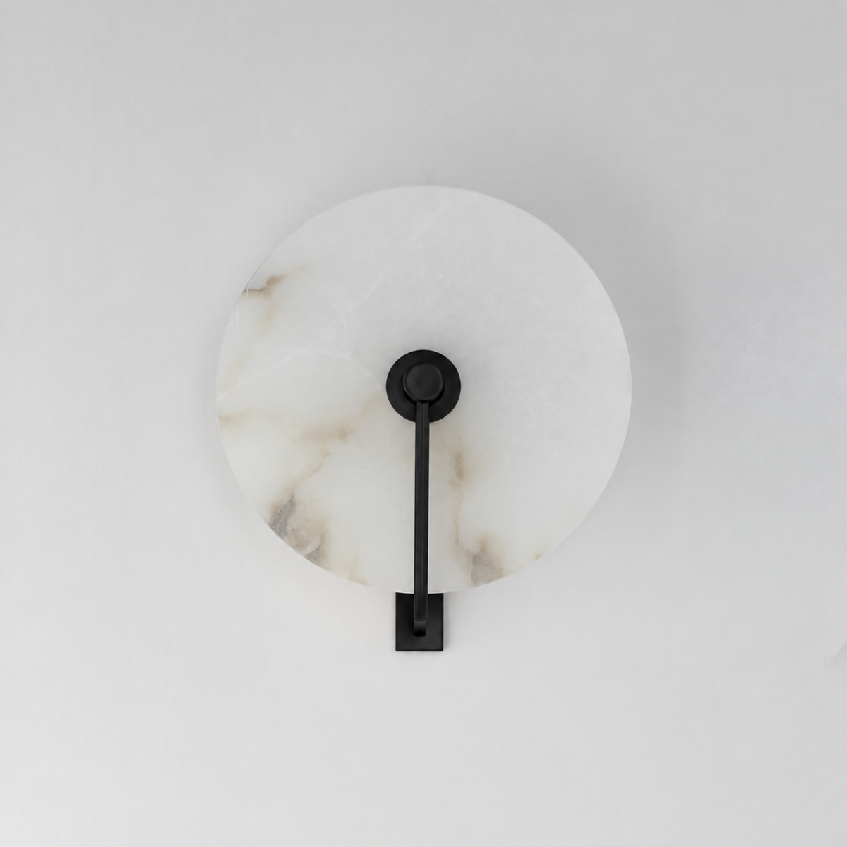 This Clérachic wall sconce in matte black shows the alabaster disc's natural veining, unlit on a plain backdrop.