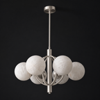 Front view of this Clérachic chandelier in brushed nickel, alabaster shades clustered around the open ring frame.