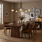 A matte-black Clérachic chandelier hangs low over a walnut dining table set beneath framed artwork.