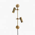 Studio shot of this Clérachic plug-in spotlight in bronze finish, its two ribbed heads mounted along a vertical rail.