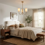 Above a bed with a cream upholstered headboard, this Clérachic chandelier hangs in a warm brass finish.