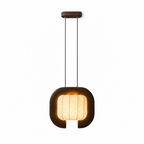 This dark wood, closed-loop Clérachic pendant appears here in a plain studio shot, its shade glowing warm beneath a round canopy.