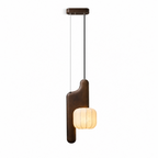 Photographed in studio, this dark wood, bent-style Clérachic pendant shows its shade glowing at the end of a long cord.