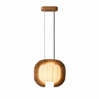 Another studio angle of this dark wood, closed-loop Clérachic pendant, its shade glowing beneath a round canopy.