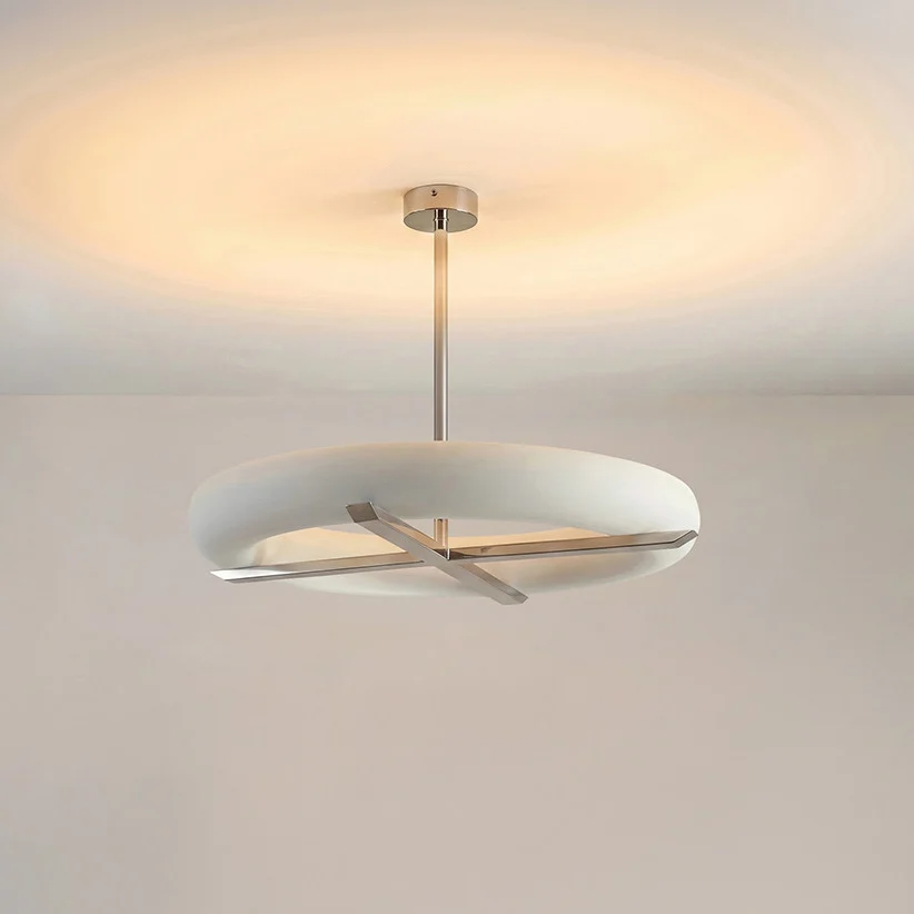 This Clérachic ceiling light in nickel glows warm against a plain backdrop, its silver cross-frame catching the light.