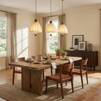 Staggered at three heights, these Clérachic pendants hang above a wood dining table near curtained windows.