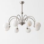 This nickel Clérachic chandelier stands unlit on a plain white background, its crown-arched arms holding eight alabaster balls.