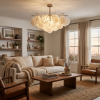 A brass Clérachic chandelier glows above a coffee table in a living room furnished with a linen sofa and leather armchairs.