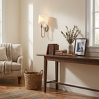 Above an entryway console with a woven basket beneath, this Clérachic sconce in brass hardware lights the corner.