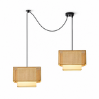 Shown from another angle, two of these Clérachic pendants swag from black ceiling plates, both glowing warm.
