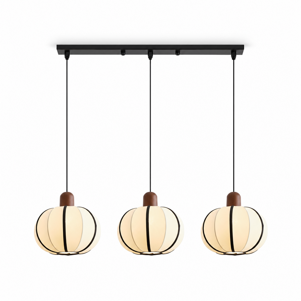 Three of these Clérachic pendants cluster from one black linear bar, their cream ribbed shades glowing in a row.