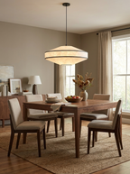 Set for a meal, a wood dining table sits below this Clérachic pendant's glowing faceted diamond paper shade.