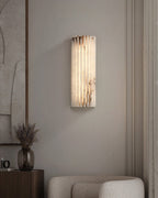 Alabaster wall light lit beside a piece of framed art