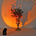 An ornate glass vase of flowers casts its shadow into the orange halo from this Clérachic projection lamp.